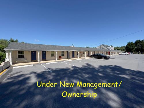 a building in a parking lot with the words under new management ownership at Relax Inn in Natural Bridge in Natural Bridge