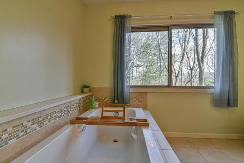 a room with a bath tub with a table and a window at The Camby Cabin just 12 miles to downtown Asheville in Asheville