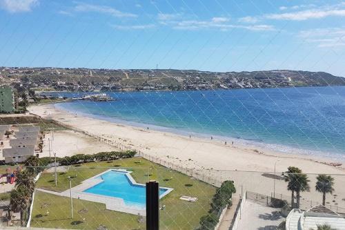 a view of a beach with a swimming pool at Hermoso apartamento a pasos de la playa in Coquimbo