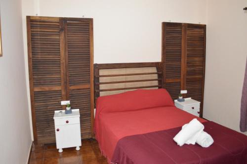 um quarto com uma cama vermelha e persianas de madeira em Lo de Annie Depto 2 em Posadas