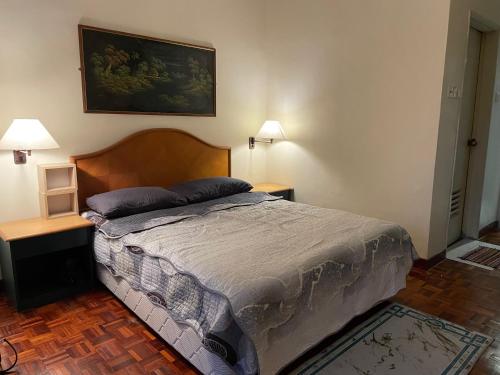 a bedroom with a bed with two tables and two lamps at Seri Bulan Apartment Teluk Kemang in Port Dickson