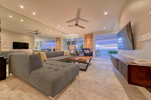 a living room with a couch and a flat screen tv at Maxwell Residences at Indah in Puerto Vallarta