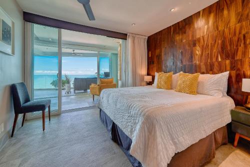 a bedroom with a large bed and a large window at Maxwell Residences at Indah in Puerto Vallarta