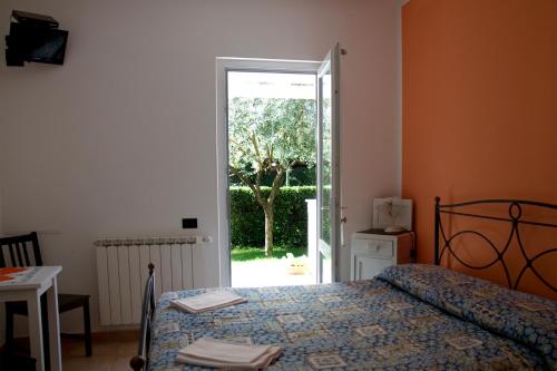 1 dormitorio con 1 cama y puerta corredera de cristal en B&B Cinque Terre Da Levanto, en Levanto