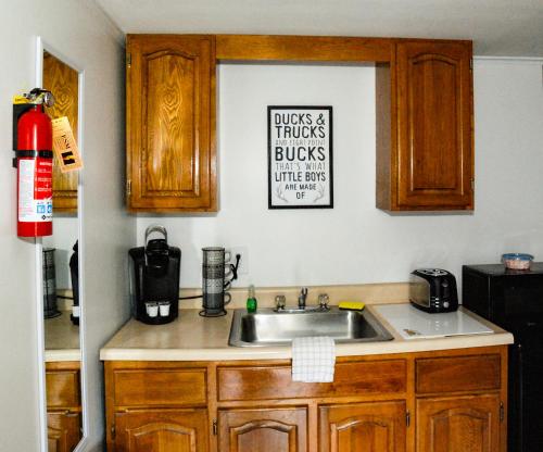 a kitchen with a sink and a sign on the wall at Maple Leaf Lodge in Schroon Lake