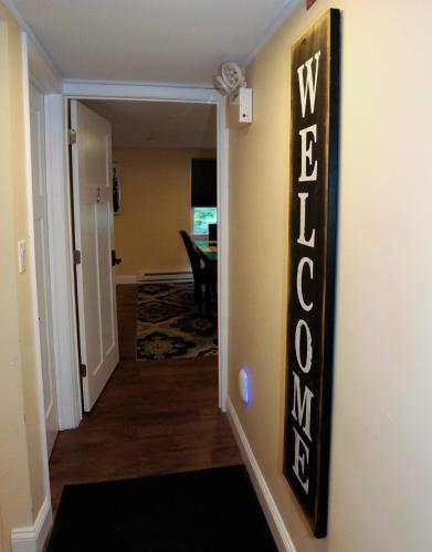 a hallway with a wayfinding sign on a wall at Maple Leaf Lodge in Schroon Lake