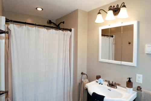 a bathroom with a white sink and a mirror at Maple Leaf Lodge in Schroon Lake