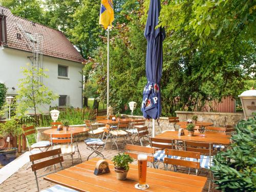 a patio with tables and chairs and an umbrella at Kärntner Stub'n in Königslutter am Elm