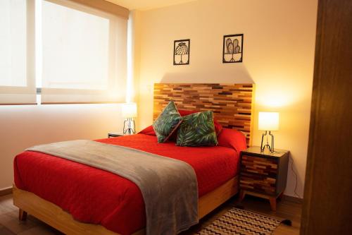 een slaapkamer met een rood bed en een raam bij Kolben Nuoma in Mexico-Stad