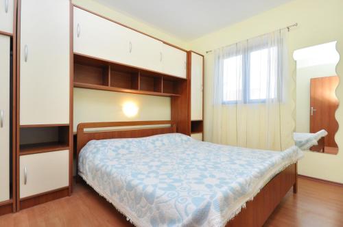 a bedroom with a large bed and a window at Apartments by the sea Vela Luka, Korcula - 9244 in Vela Luka