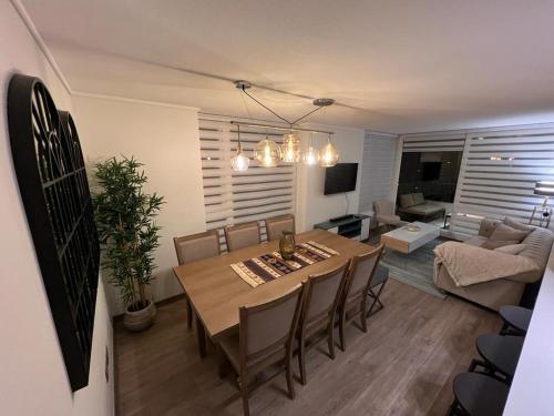 a dining room and living room with a table and chairs at Departamento Nuevo Papudo - Full equipado - 7 personas in Papudo