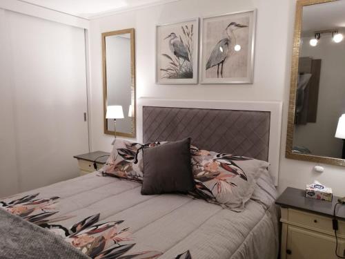 a bedroom with a bed and two mirrors on the wall at Departamento Nuevo Papudo - Full equipado - 7 personas in Papudo