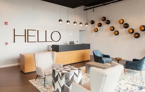 a lobby with chairs and a hello sign on the wall at Residencias Cityzen cerca del Aeropuerto in Echeverría