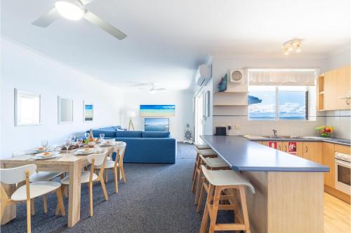 a kitchen and living room with a table and a couch at Kiah 12, 53 Victoria Pde - Panoramic water views, Wifi and Air Con in Nelson Bay