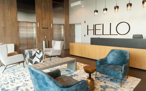 a lobby with chairs and a hello sign on the wall at Residencias Cityzen cerca del Aeropuerto in Echeverría