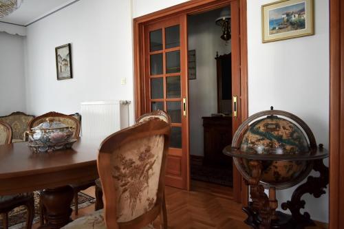 a dining room with a table and chairs and a door at Κεντρικό και ευρύχωρο οροφοδιαμέρισμα in Kastoria