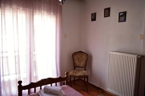 a bedroom with a chair and a radiator and a window at Κεντρικό και ευρύχωρο οροφοδιαμέρισμα in Kastoria