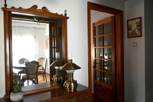 a room with a mirror and a table with a lamp at Κεντρικό και ευρύχωρο οροφοδιαμέρισμα in Kastoria