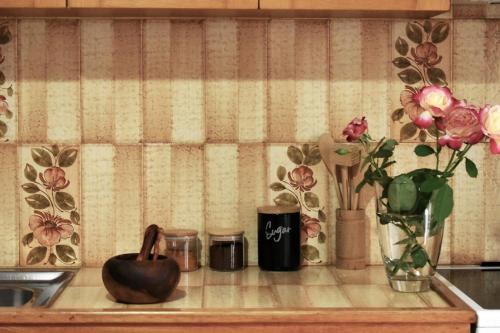 a kitchen counter with vases and flowers on it at Κεντρικό και ευρύχωρο οροφοδιαμέρισμα in Kastoria