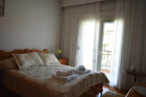 a bedroom with a bed with towels and a window at Κεντρικό και ευρύχωρο οροφοδιαμέρισμα in Kastoria