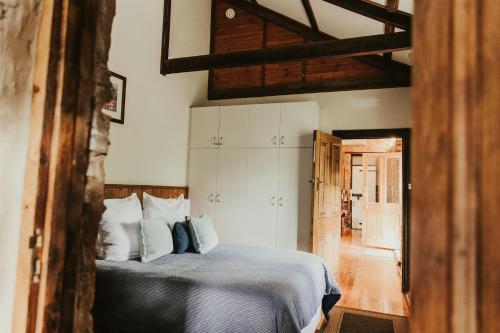 1 dormitorio con 1 cama con almohadas azules y blancas en Mintaro Cottage, en Mintaro