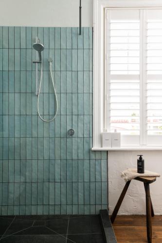 a bathroom with a shower with green tiles at Henry’s on Balfour - Historic understated luxury in Launceston