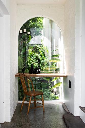 a wooden table with a chair in front of a window at Henry’s on Balfour - Historic understated luxury in Launceston