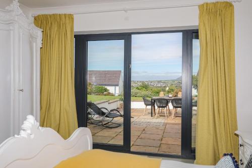 a bedroom with a sliding glass door leading to a patio at Trem Y Borth Apartment in Abersoch