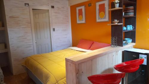 ein Schlafzimmer mit einem Bett und zwei roten Stühlen in der Unterkunft Manhuemalal in Villarrica