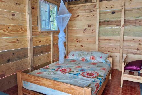 a bedroom with a bed in a wooden cabin at Private Over-Water Cabin on paradise San Blas island in Waisalatupo