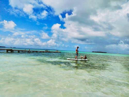 a man and a dog on a boat in the water at Private Over-Water Cabin on paradise San Blas island in Waisalatupo