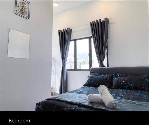 Un dormitorio con una cama con una toalla. en New 2 storey-Majestic Homestay 3 min to Night Market en Brinchang