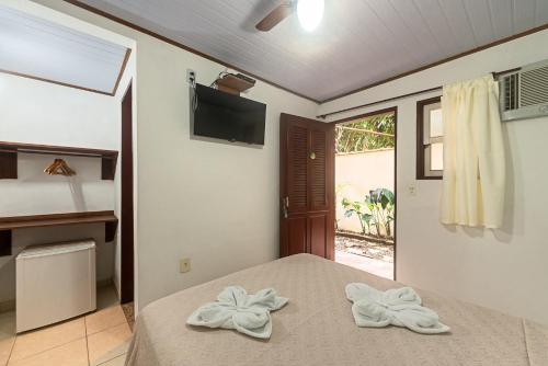 um quarto com uma cama com toalhas em Pousada Sol e Mar em Paraty