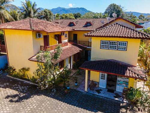 an aerial view of a house with mountains in the background at Pousada Sol e Mar in Paraty