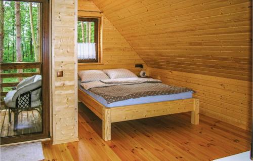 1 cama en una cabaña de madera con ventana en Cozy Home In Ostroda With Wifi en Ostróda