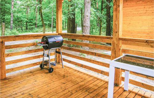 a grill on a wooden porch of a cabin at 2 Bedroom Pet Friendly Home In Ostroda in Ostróda