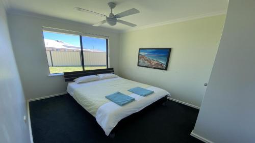 a bedroom with a bed with two pillows and a window at Adriana Retreat, 20 Adriana Retreat in Jurien Bay