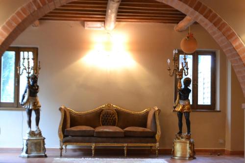 a living room with a couch and two statues at Relais Ciavatta Country Hotel in Montemerano