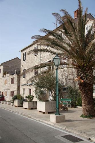 a palm tree and a street light in front of a building at Apartments Sonja in Pučišća