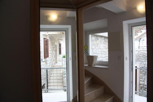 a room with a staircase and two windows at Apartments Sonja in Pučišća