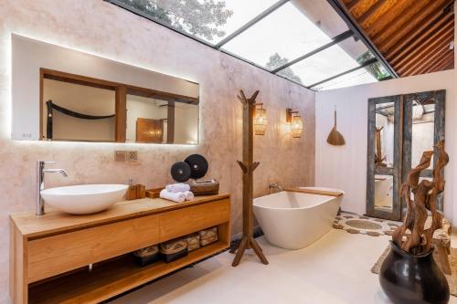 a bathroom with a large mirror and a tub and a sink at Luxury Villa in City Center w/ Natural Pool La Bohemia Residence Villas in Ubud
