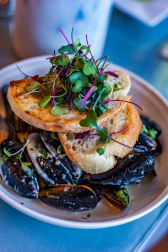 a plate of food with waffles and mussels at The Tranquil House Inn in Manteo