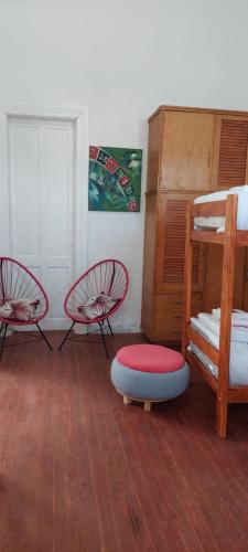 a room with two bunk beds and a ottoman at Hostel La Cumbre Tandil in Tandil