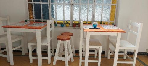 cocina con 2 mesas y taburetes en una habitación en Hostel B&B Tandil en Tandil