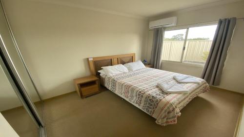 a bedroom with a bed and a window at Unit 63 Seafront Estate in Jurien Bay