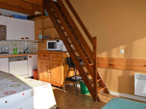 une cuisine avec un escalier en bois menant à une cuisine dans l'établissement Appartement cosy avec mezzanine et parking, proche des pistes - FR-1-592-47, à Bolquère-Pyrénées 2000