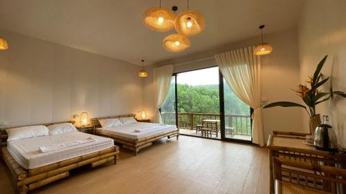 a bedroom with two beds and a balcony at OMTARA RETREAT in Yen Bai