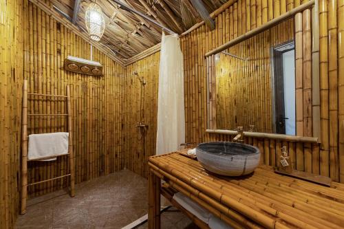 Baño de bambú con lavabo y espejo en OMTARA RETREAT, en Yen Bai