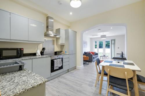 cocina y sala de estar con mesa y sillas en The Norfolk - comfortable 1 Bedroom Apts with Parking, Maidenhead by 360Stays, en Maidenhead
