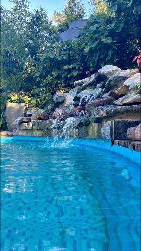 a pool with a waterfall and blue water at Posada Agua Marina in La Paloma
